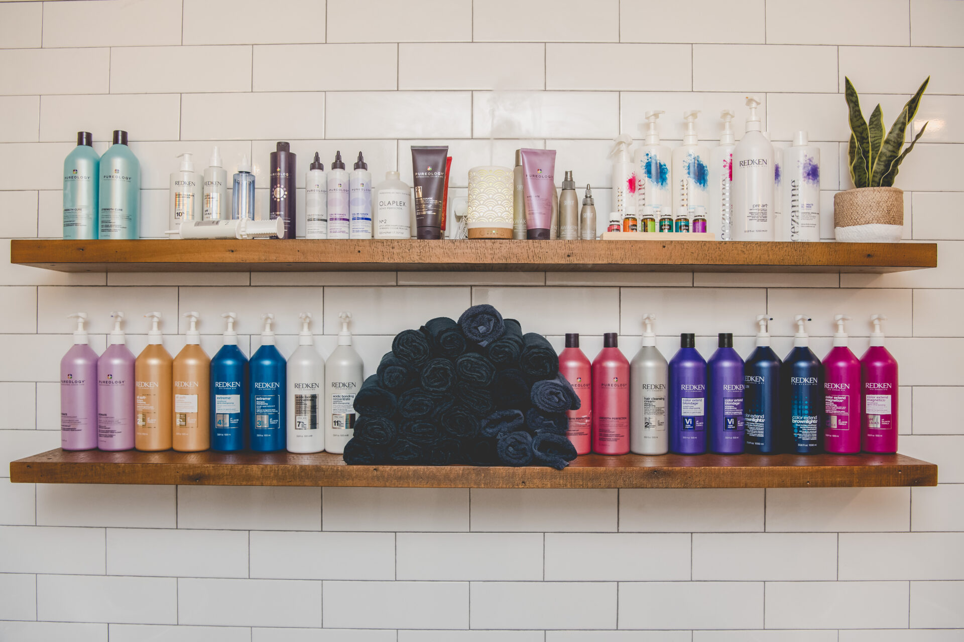 A shelf with many bottles of hair products on it