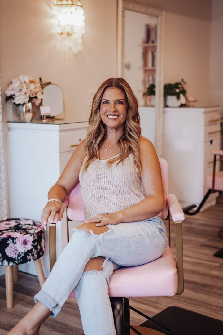 A woman sitting in a chair smiling for the camera.